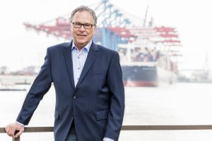 Portrait von Wolf Achim Wiegand/ FDP vor Hafenkulisse