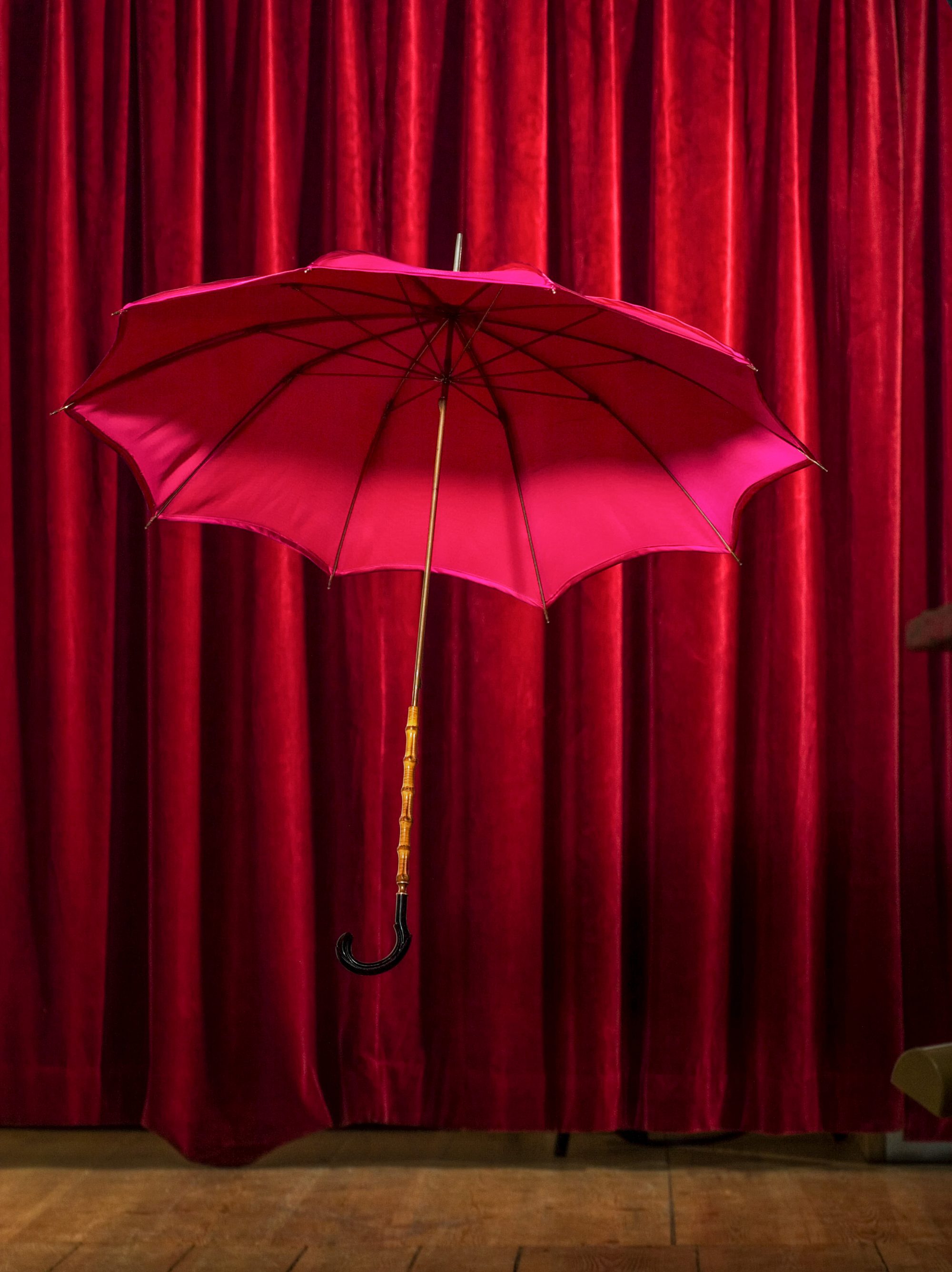 fliegender-regenschirm-mit-vorhang-syrealistisch-rot-