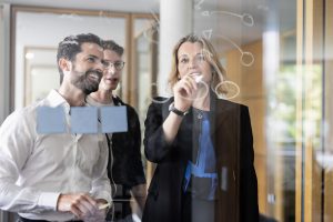 Drei Mitarbeiter bei der Teamarbeit in einem modernen Unternehmen.