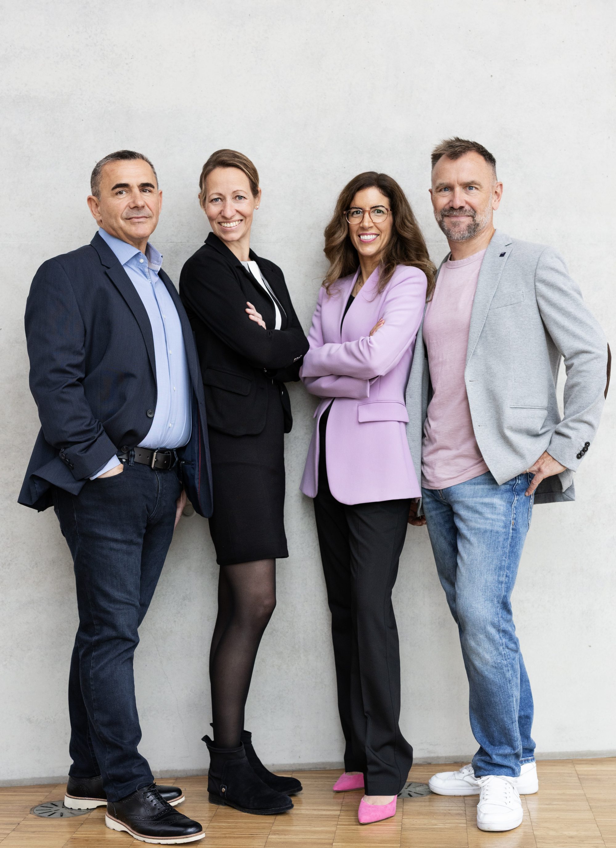 Vier Mitglieder von Bündnis Technik stehen gemeinsam vor einer hellen Betonwand in Frankfurt.